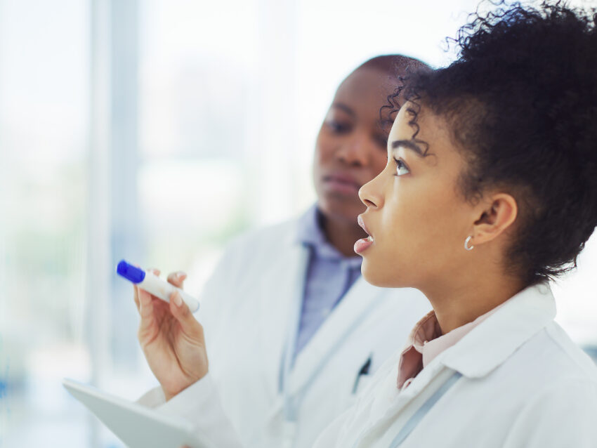 female scientist writing on a whiteboard