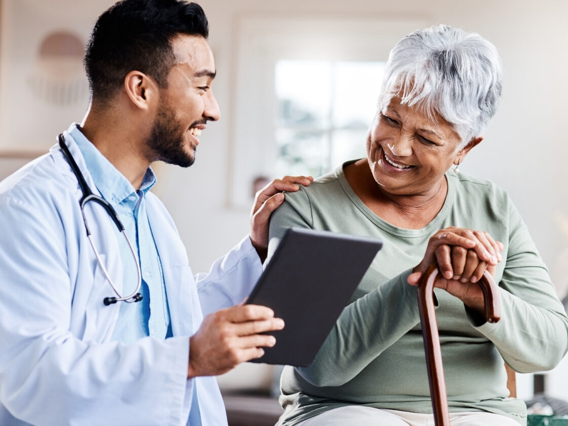 doctor sharing information on tablet with an older patient