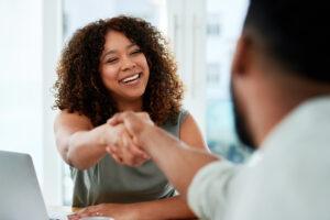 businesswoman and businessman shaking hands during a meeting