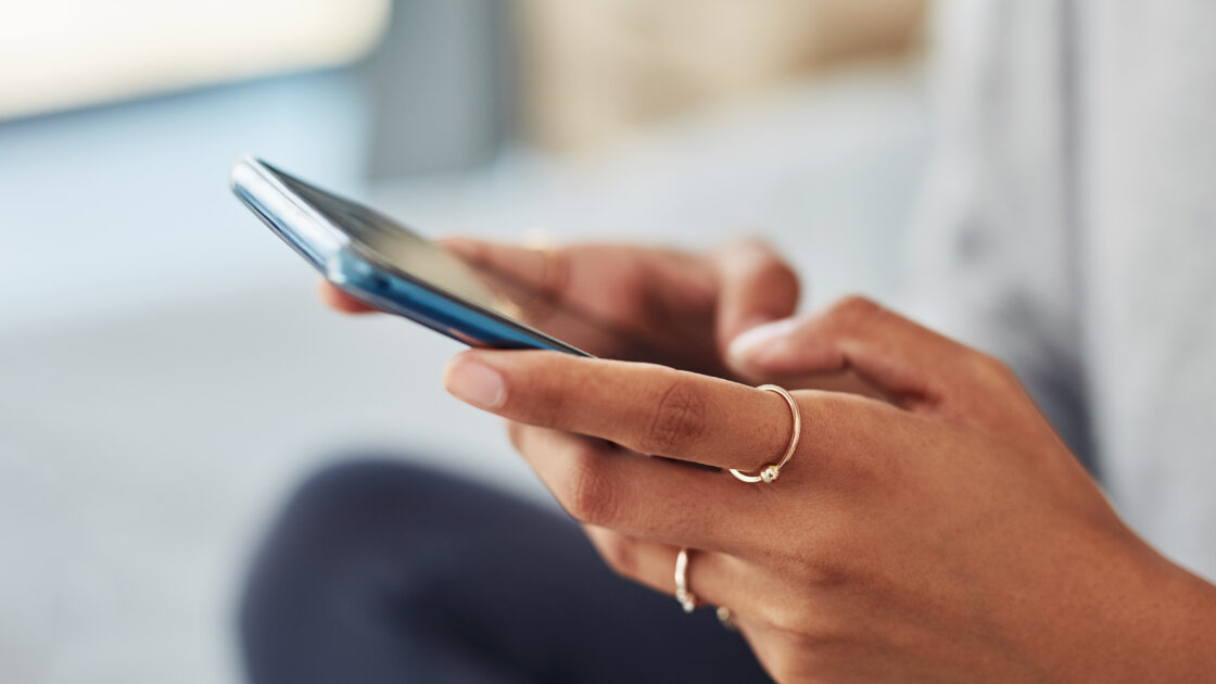 close up of women holding phone and texting