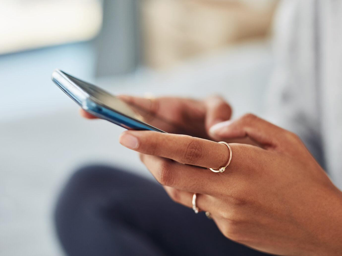 close up of women holding phone and texting