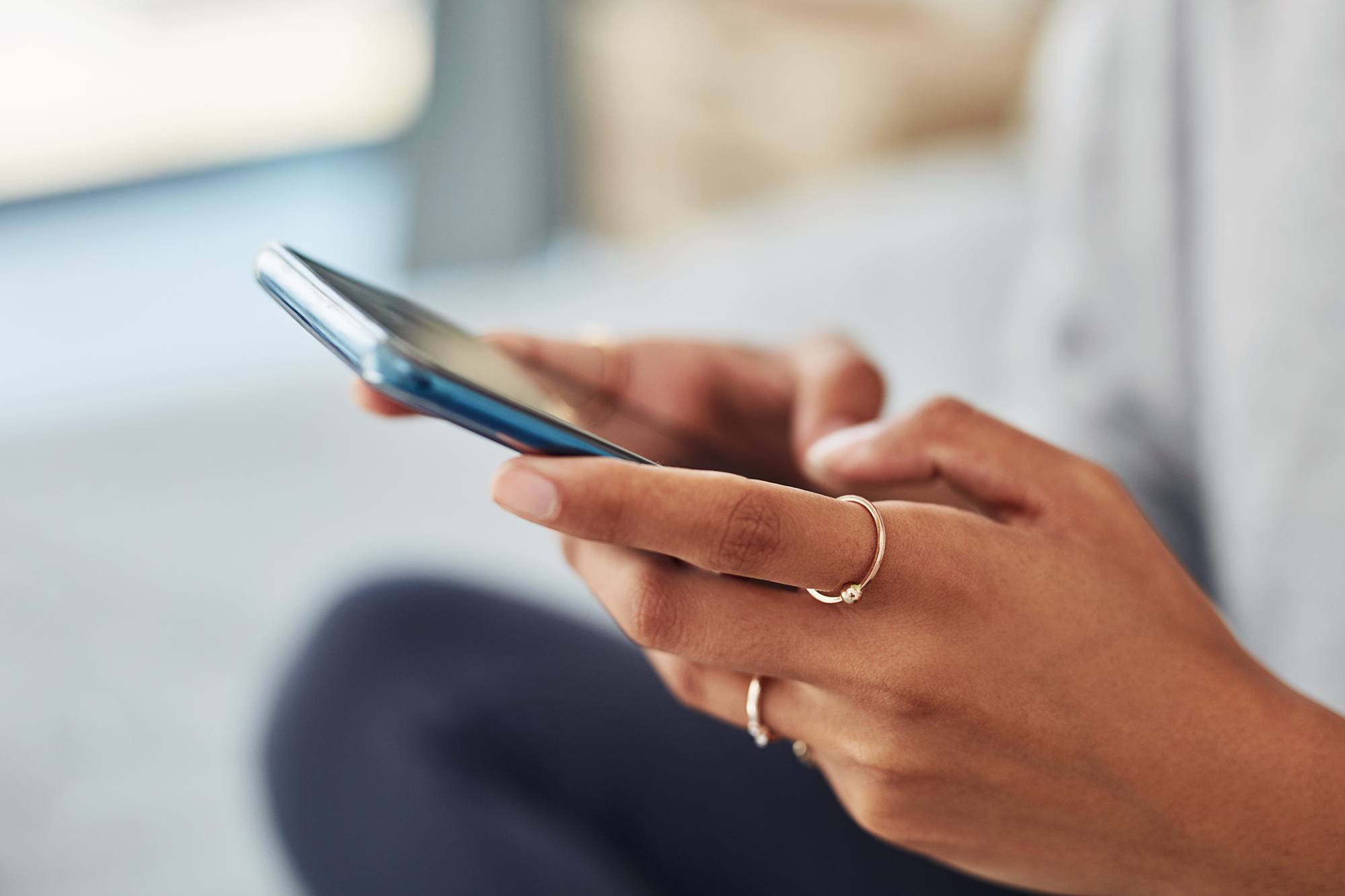 close up of women holding phone and texting