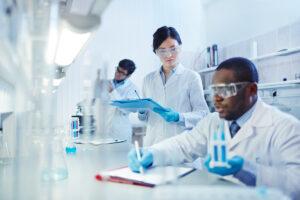 male scientist taking notes on vials