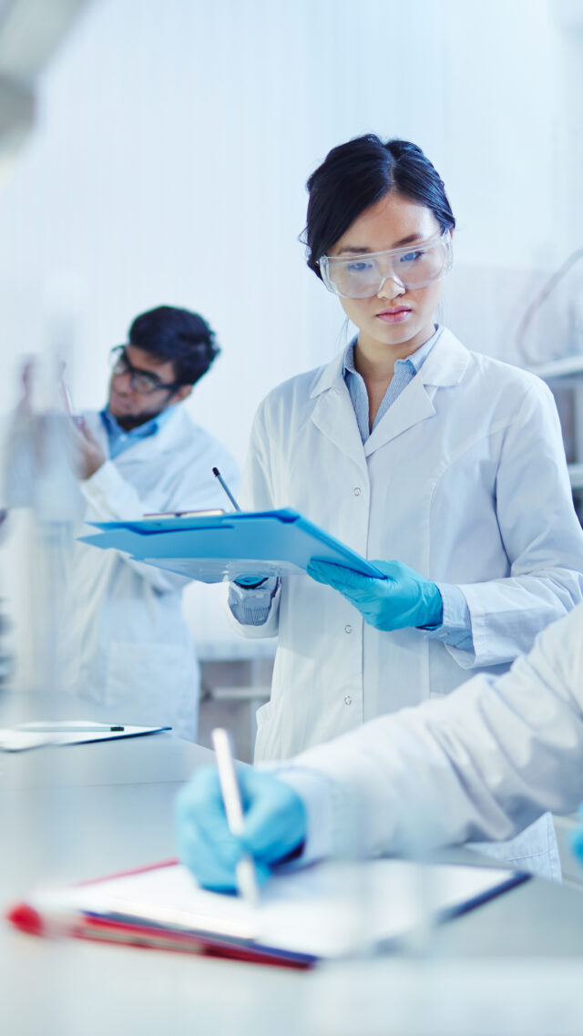 male scientist taking notes on vials