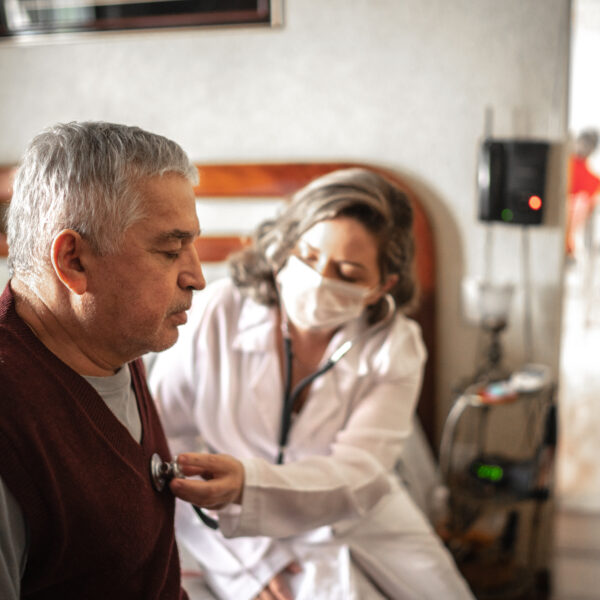 nurse listening to heartbeat of senior man