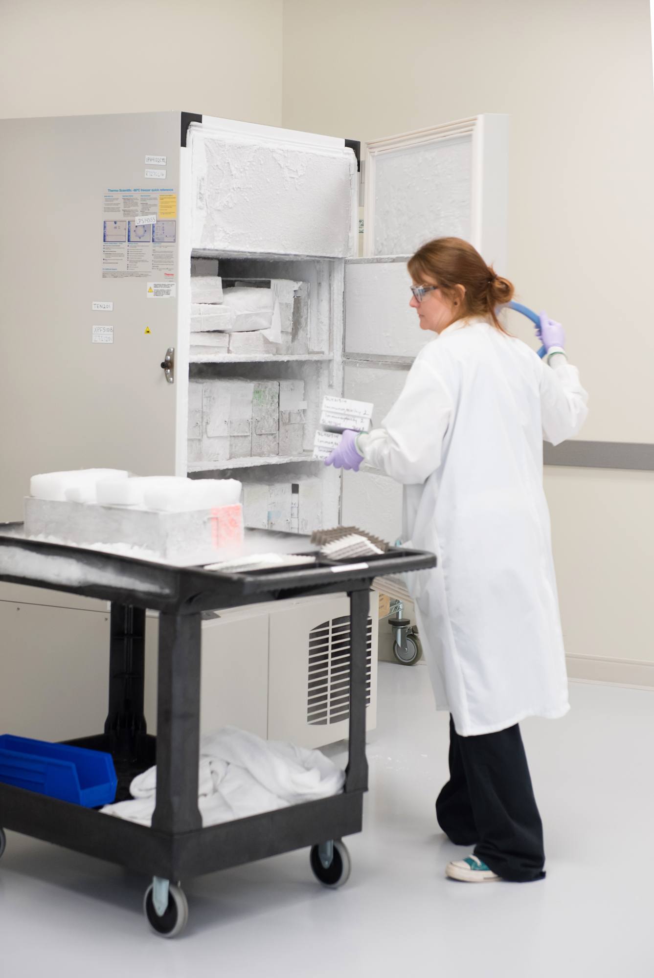 women scientist retrieving samples from fridge