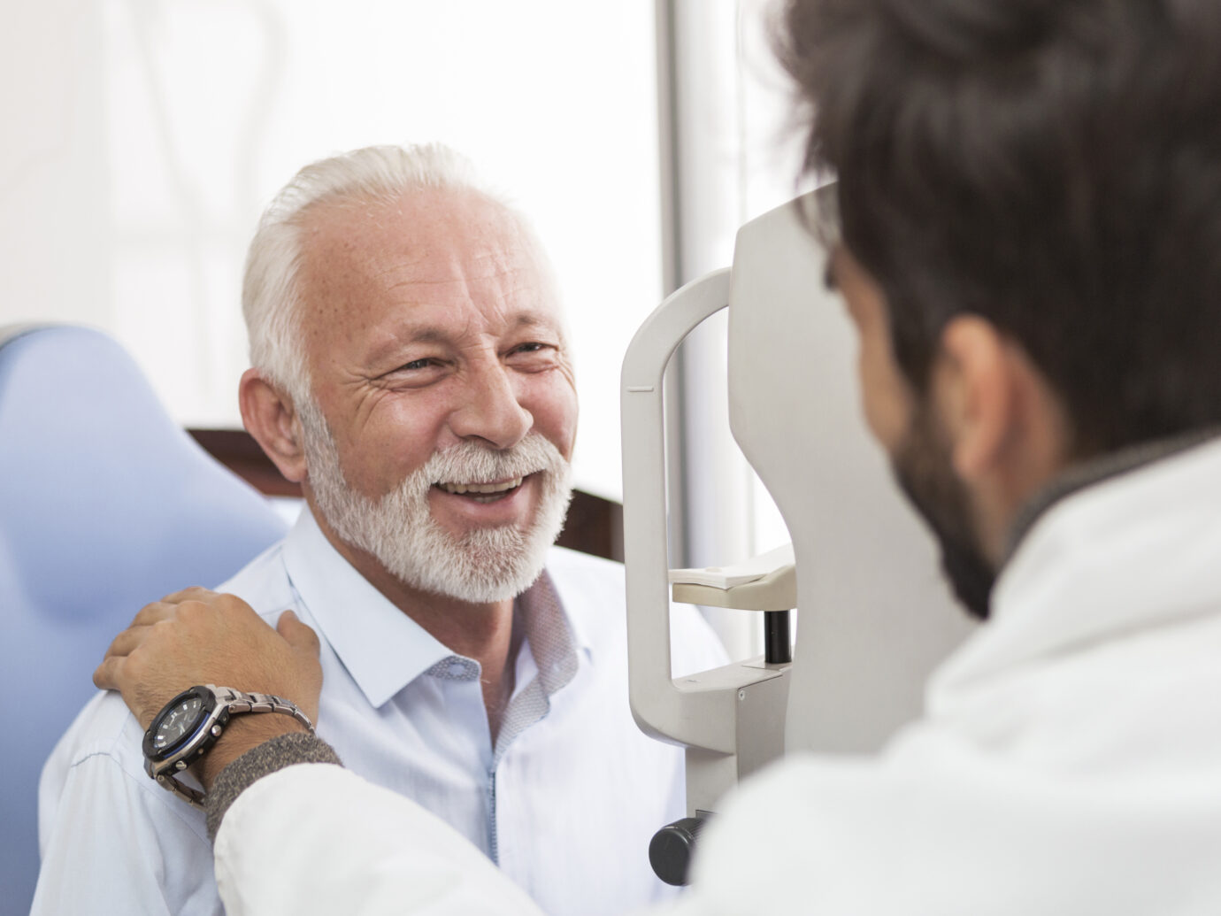 Senior Patient consulting With Doctor In Office smiling