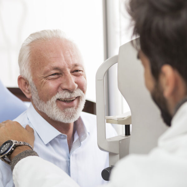 Senior Patient consulting With Doctor In Office smiling