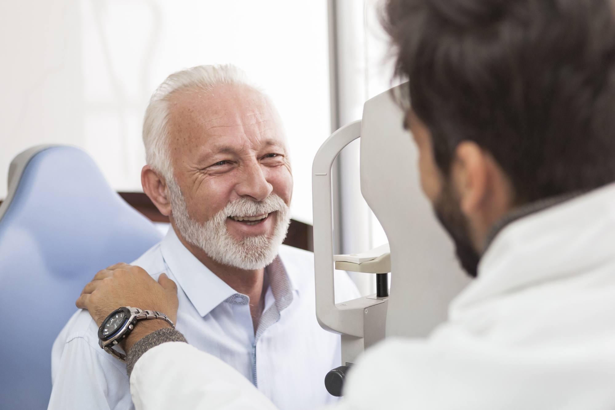 Senior Patient consulting With Doctor In Office smiling