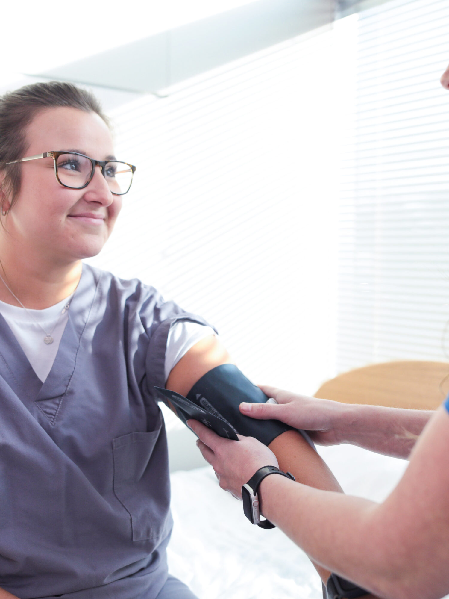 nurse practicing on taking blood pressure on another nurse