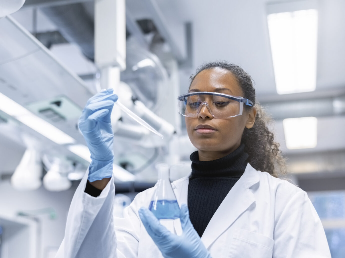 Woman scientist experimenting with chemicals in lab