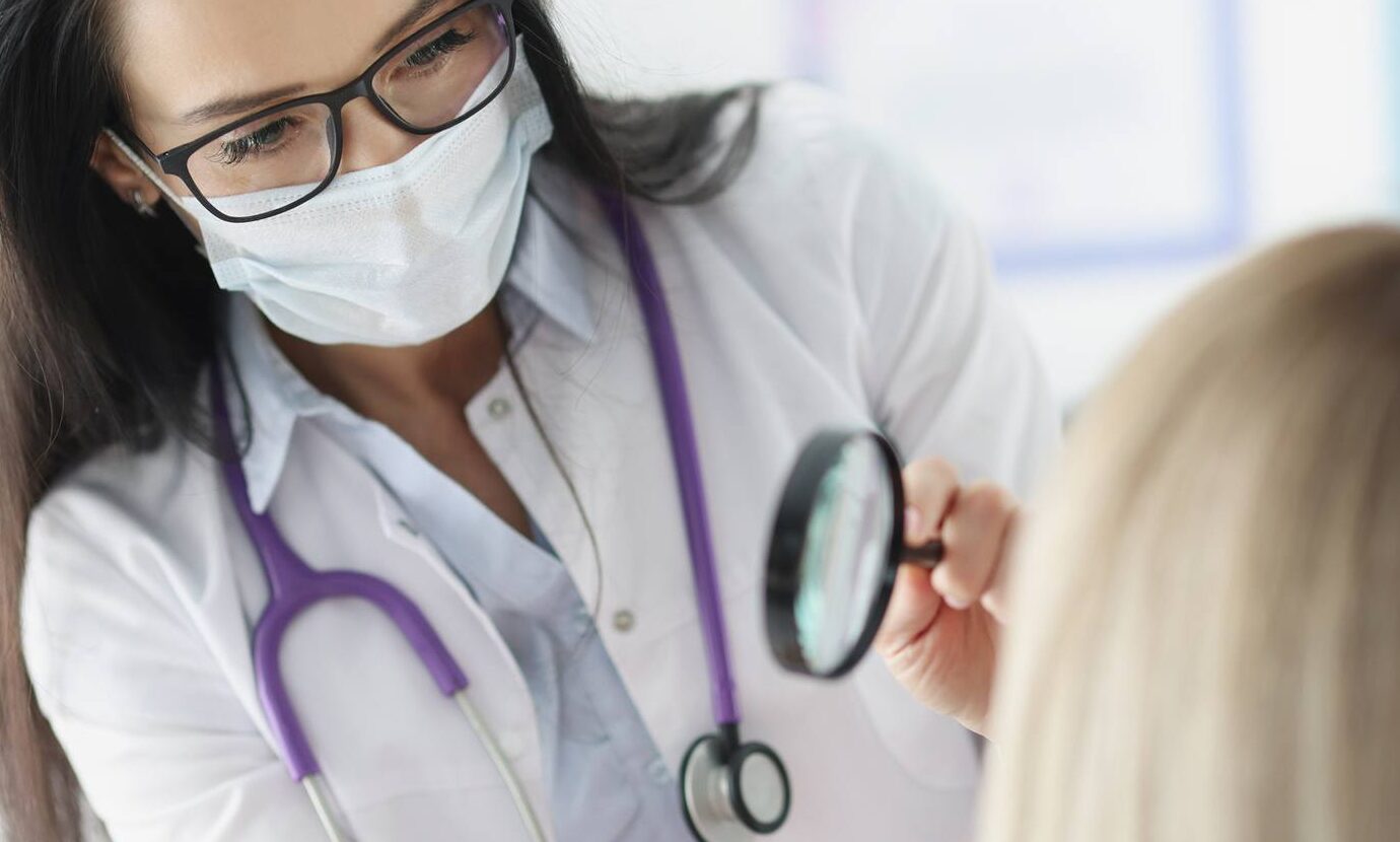 Doctor examining skin on a patient's face