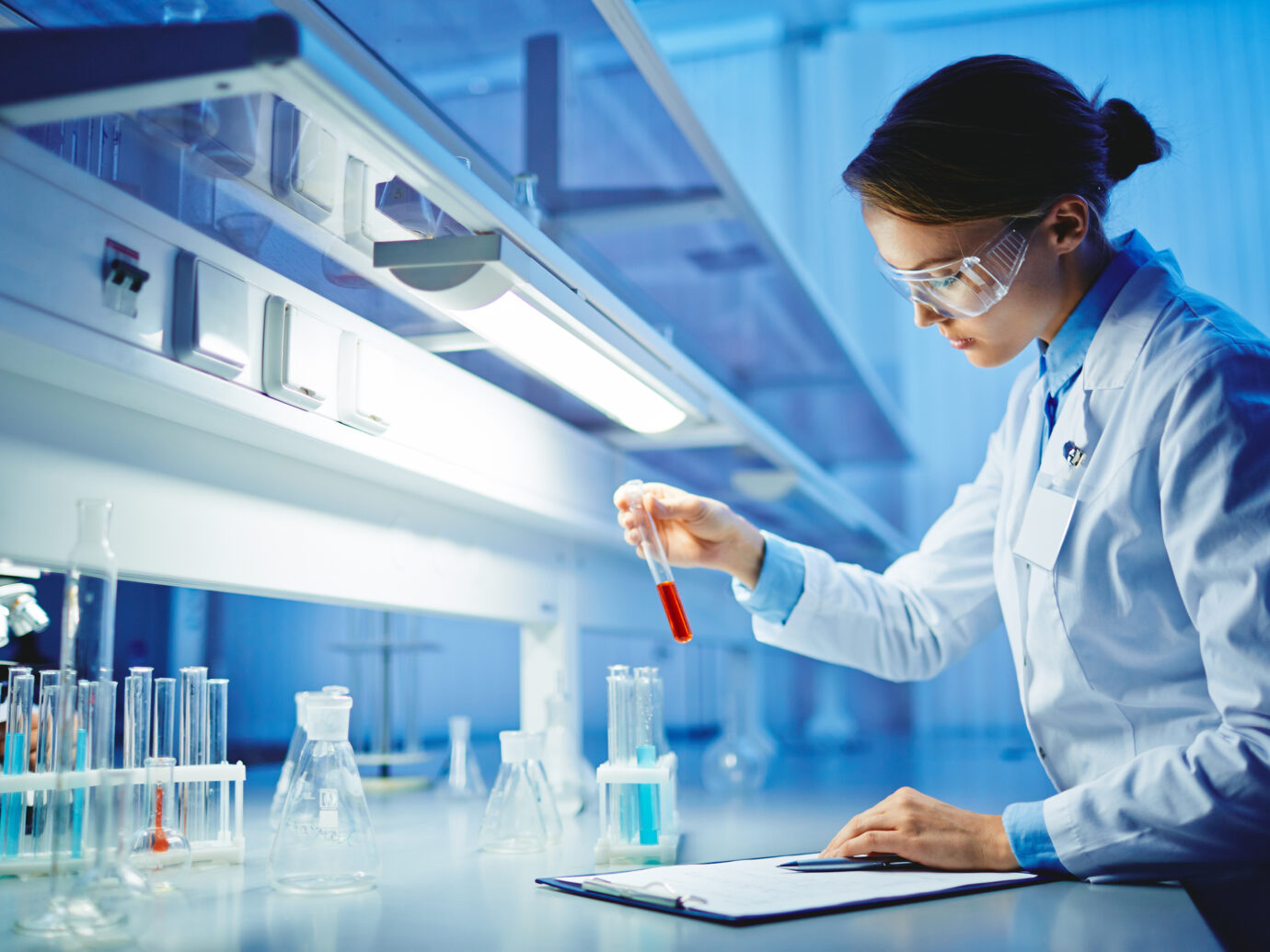 Young woman working with liquids in glassware