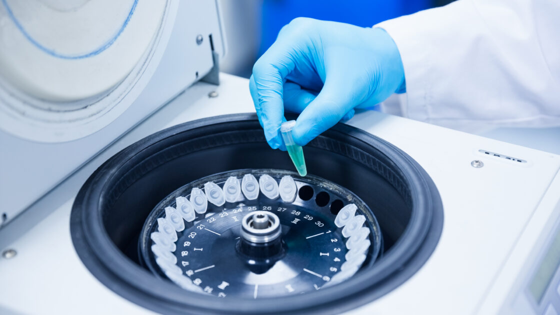 Close up of a chemist using a centrifuge in lab