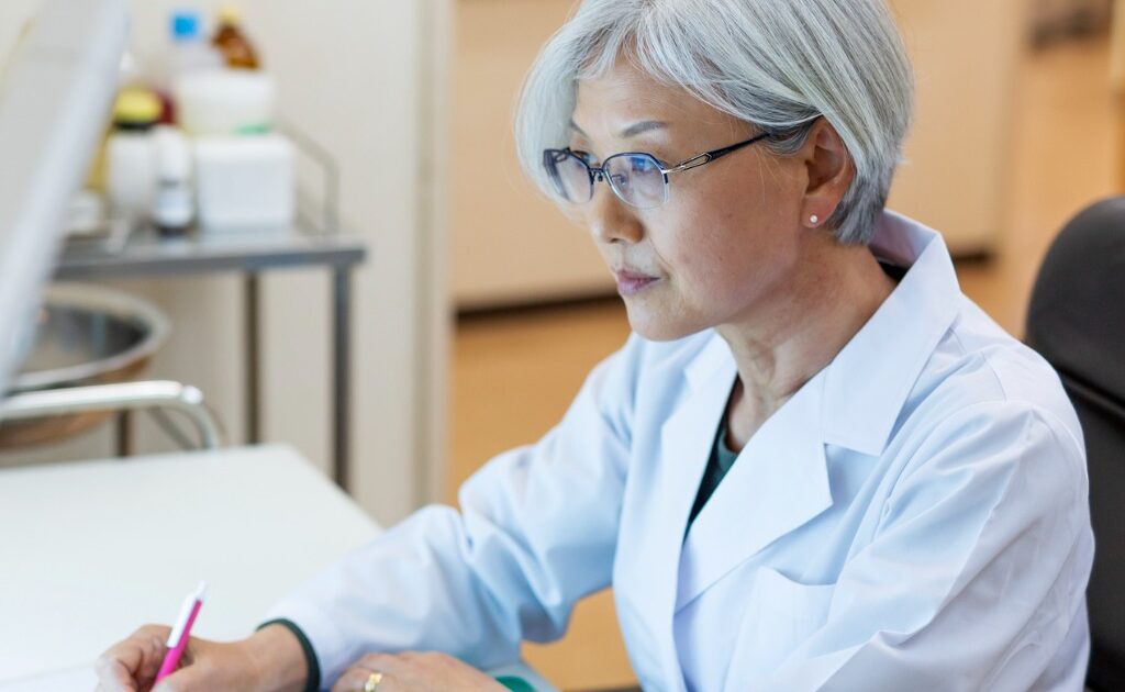 Doctor at a desk looking at a computer