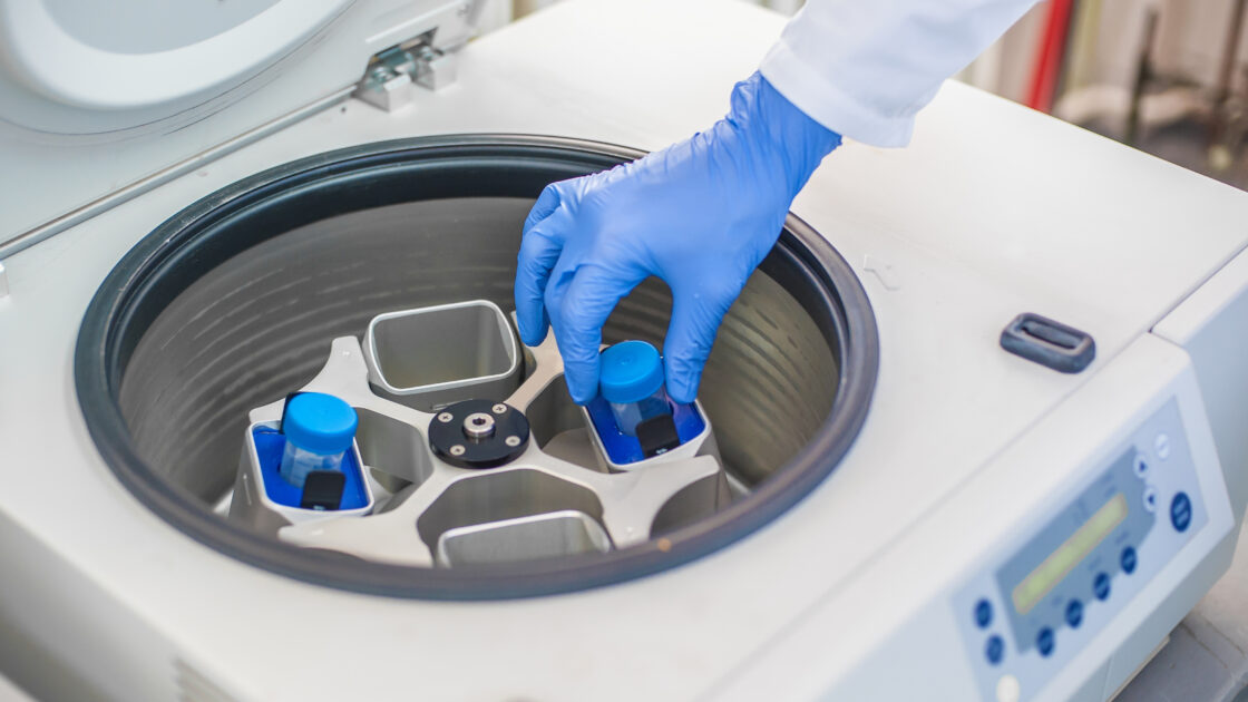 Technician loading a sample to centrifuge machine