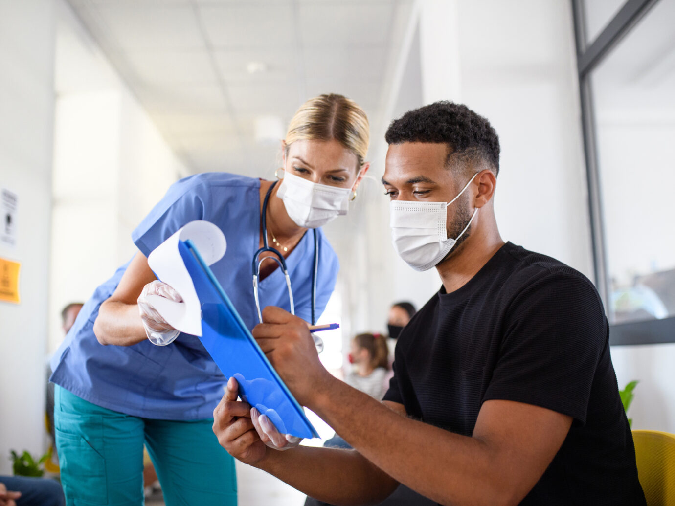 Doctor watching herpatient sign paperwork