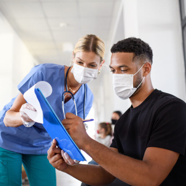 Doctor watching herpatient sign paperwork