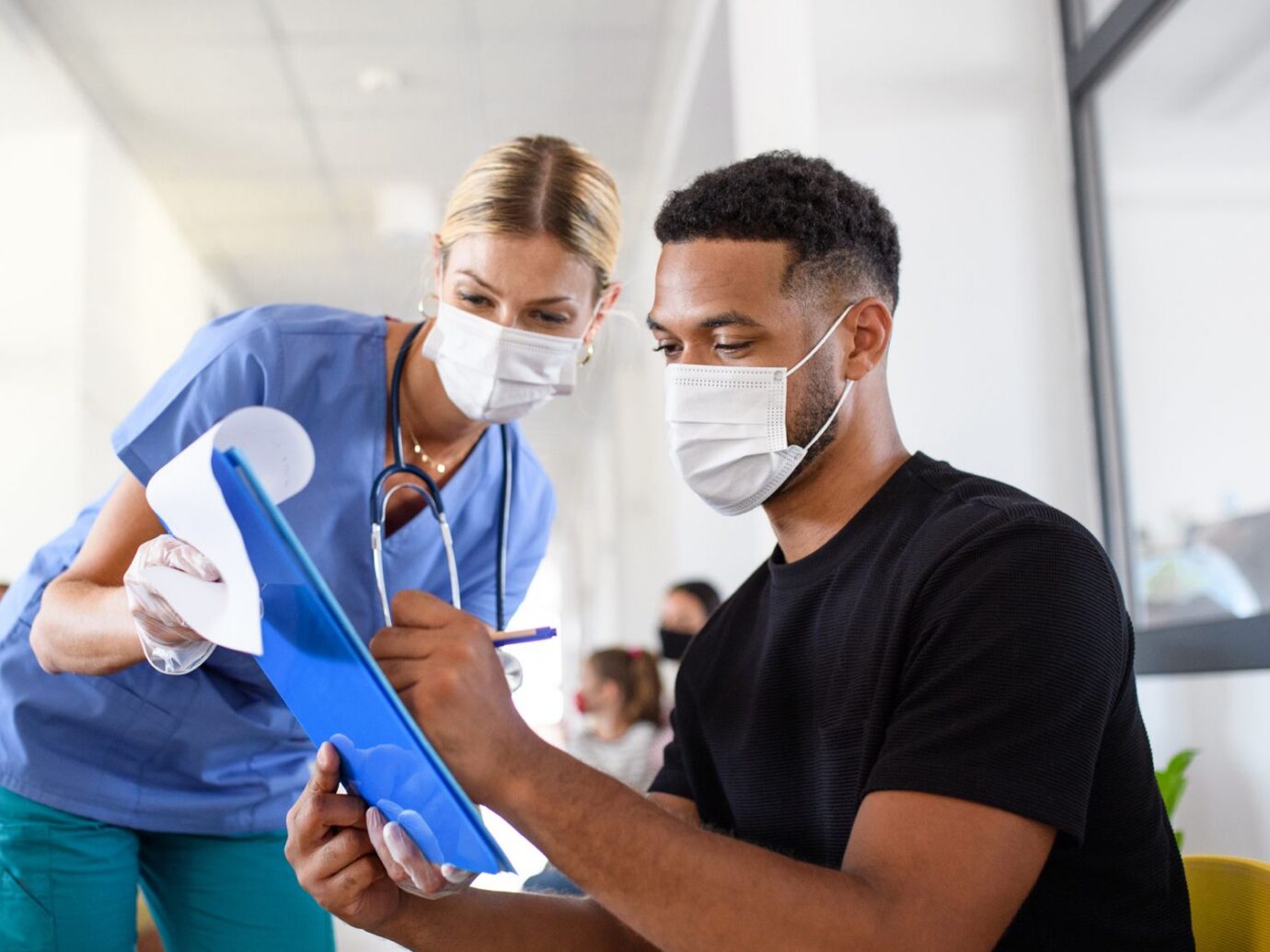 Doctor watching herpatient sign paperwork
