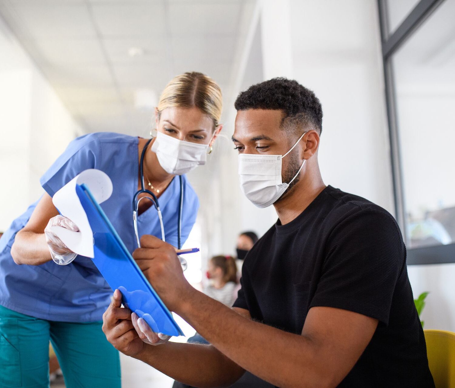 Doctor watching herpatient sign paperwork