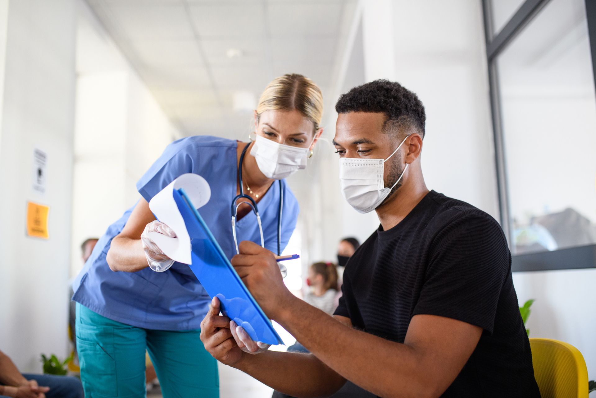 Doctor watching herpatient sign paperwork