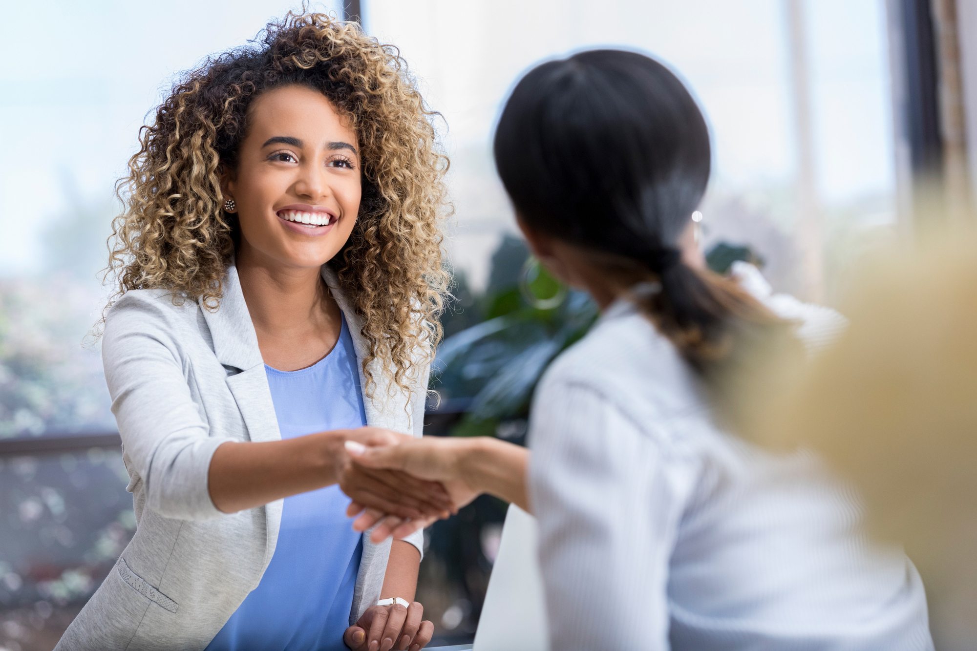 Young businesswoman greets colleague