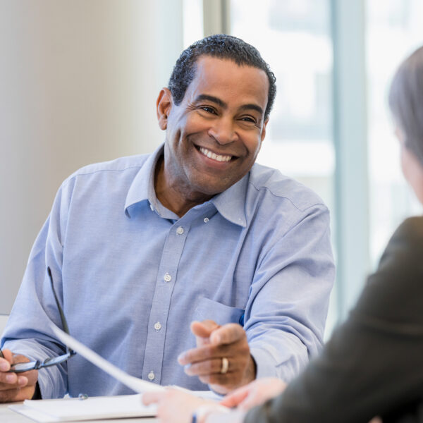 doctor smiles and gestures while discussing the paperwork