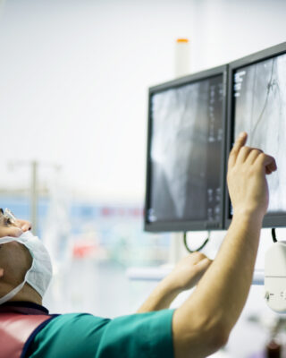 Cardiologist doctors are in a angio operation, one of the doctors following the LCD screens for the stent... ( real life )